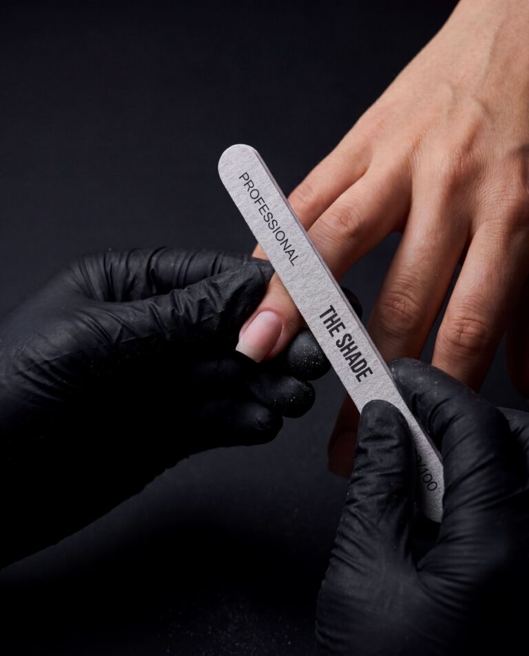 Dry manicure at The Shade — a specialist shaping a nail with a branded professional file